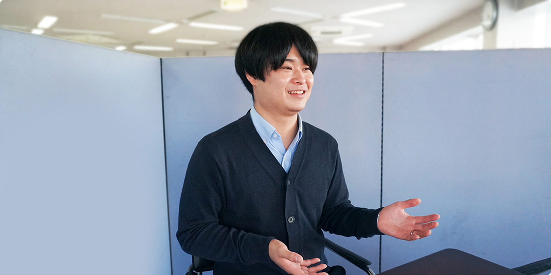 フィールドサービス部の出張修理エンジニアが笑顔で立っている様子